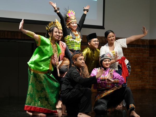 A group of students in traditional Indonesian costume from different regions pose after performing a dance together.