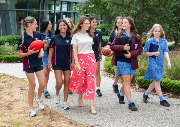 A group of Mentone Girls SC students walking with a teacher